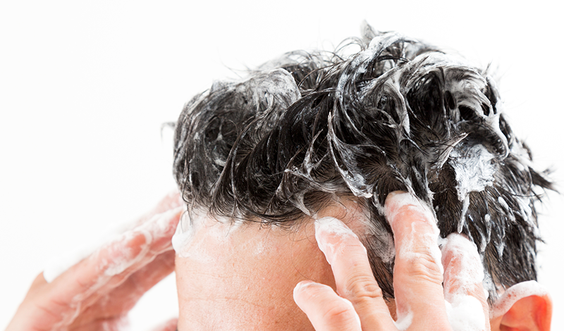 側頭部をシャンプーする男性