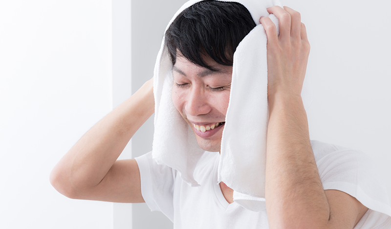 タオルで頭を拭く男性