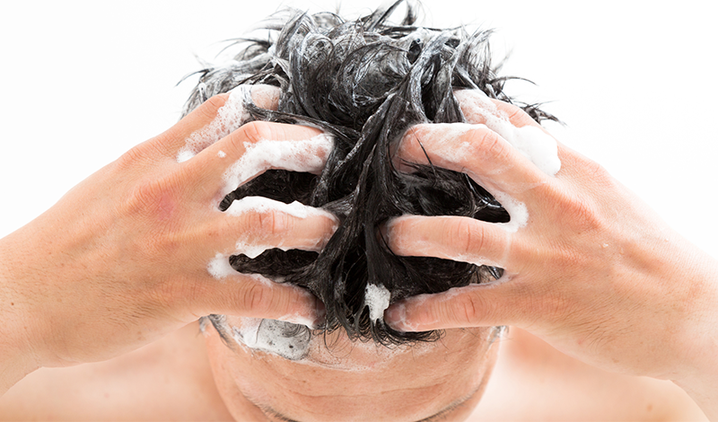 爪を立ててシャンプーする男性