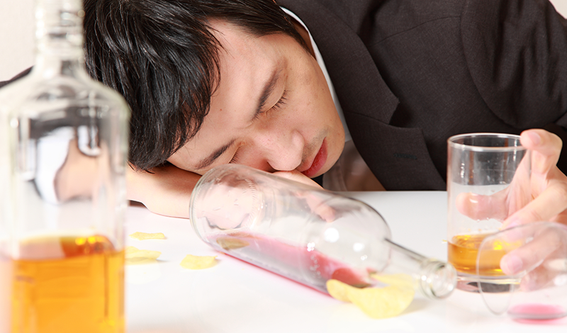 泥酔し、寝る男性