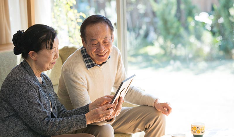 自宅で座り、夫婦で写真を見る様子