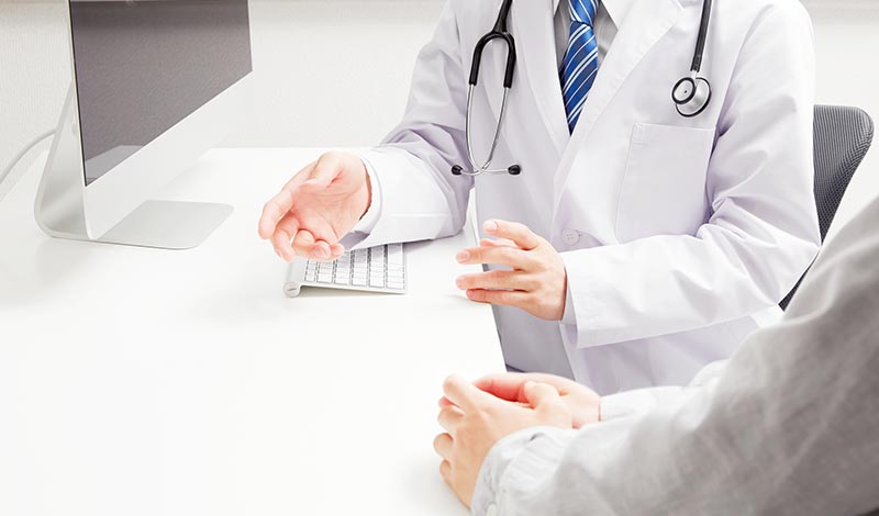 病院で診断を受ける男性