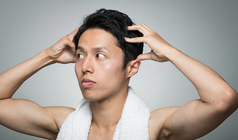 頭皮マッサージする男性