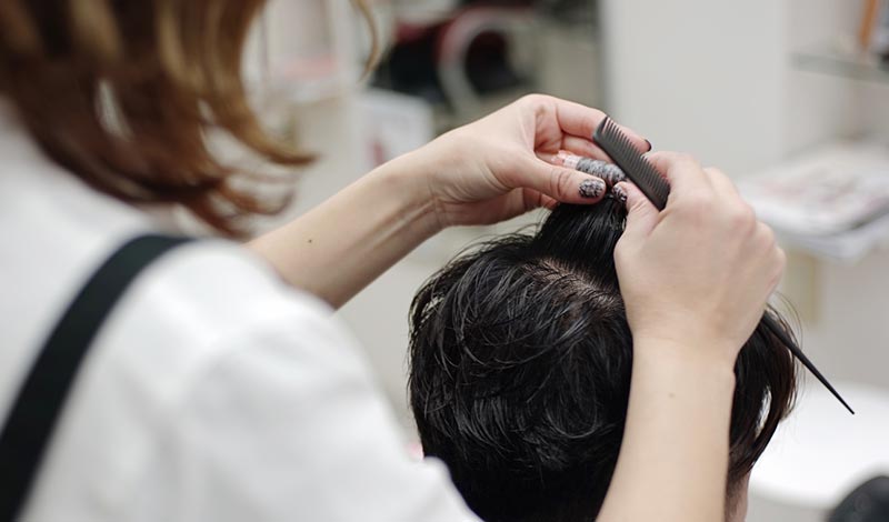 パーマをかけられる男性