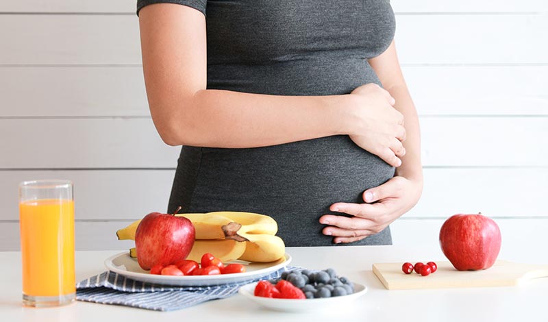 お腹を抱える女性