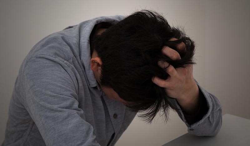 頭を気にする男性