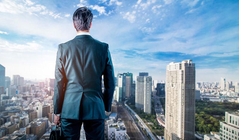 ビル街を見下ろすスーツの男性