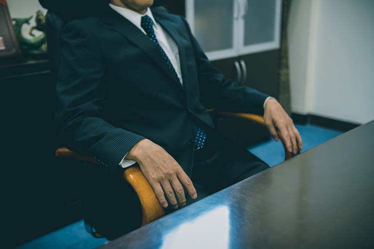 いすに座る重役の男性
