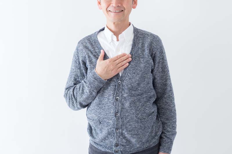 胸に手を当てて安心する男性