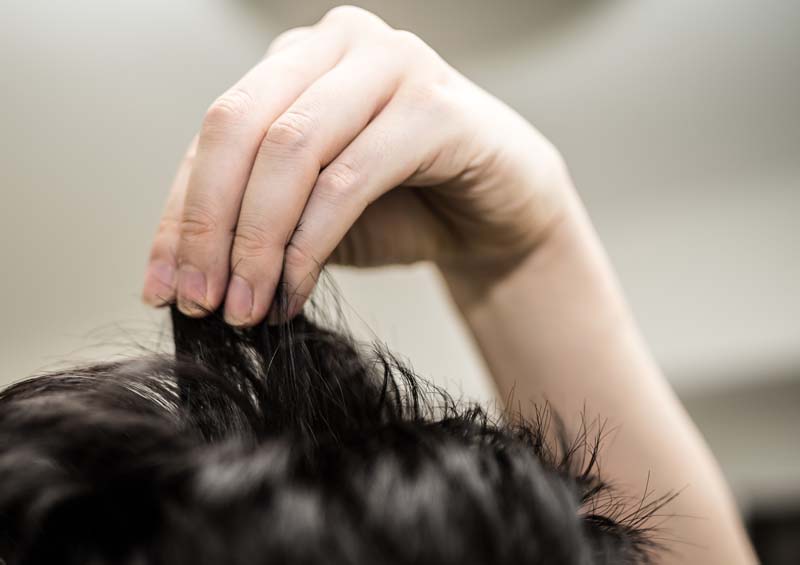 髪をつまむ