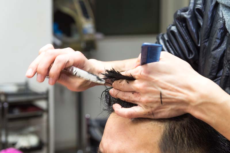 前髪を切る男性