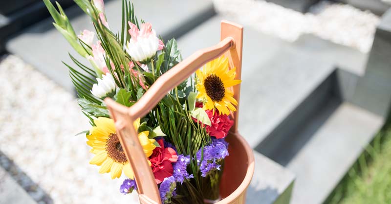 お墓とカラフルな花