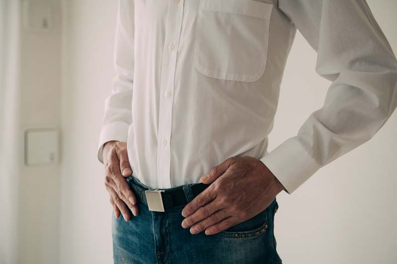 腰に手を当てる男性