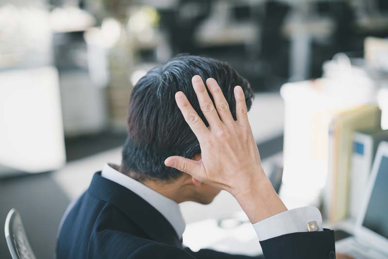 髪を触るサラリーマン男性