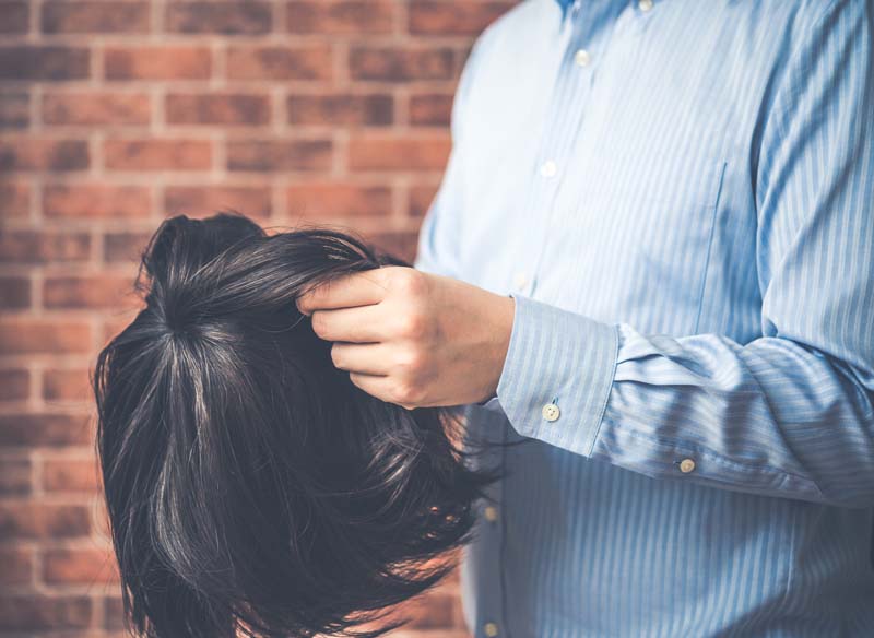 ウィッグを手にする男性