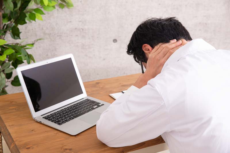 調べ、悩む男性