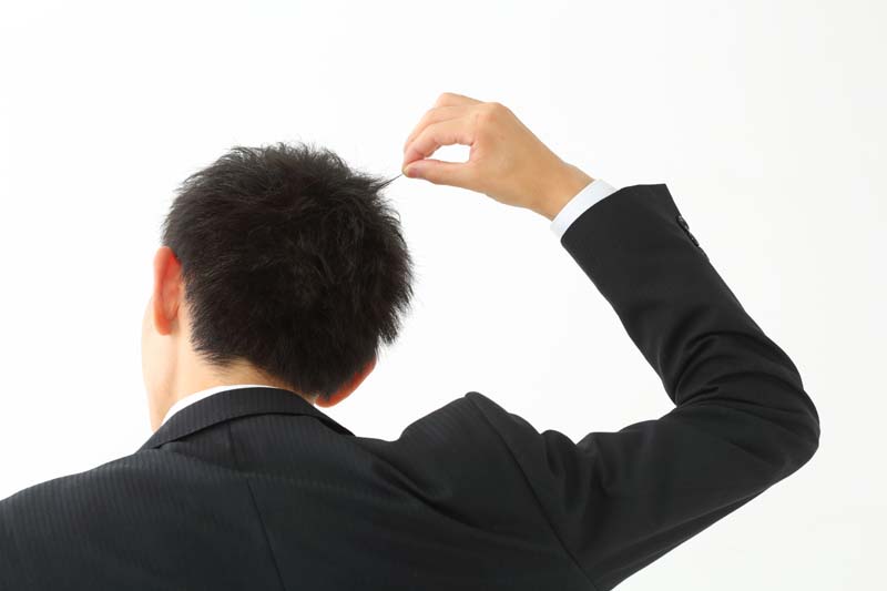 髪をつまむ男性