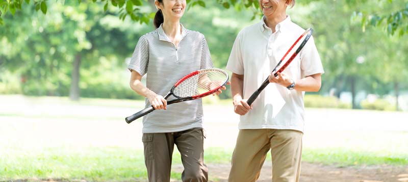 テニスラケットを持って並んで歩く