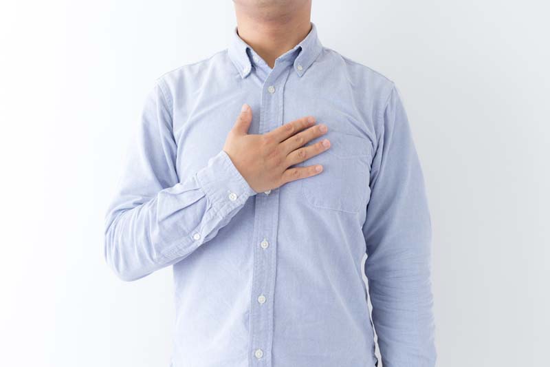 胸に手を当てる男性