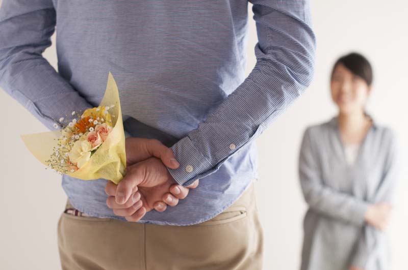 ブーケを隠し持つ男性