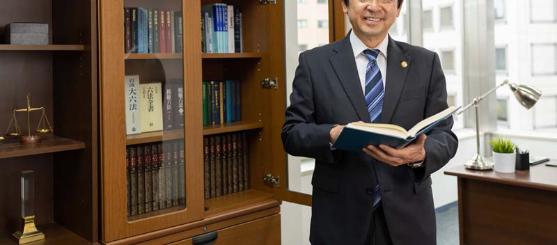 分厚い本を持つ男性