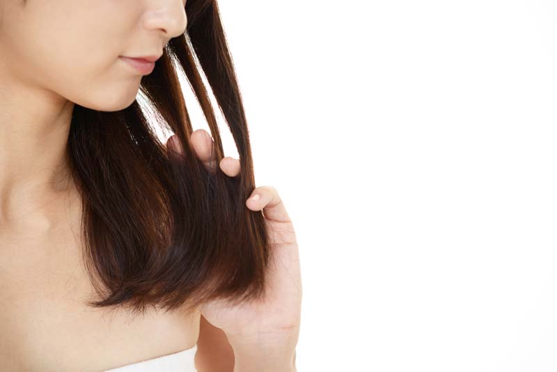 髪を気にする女性の写真