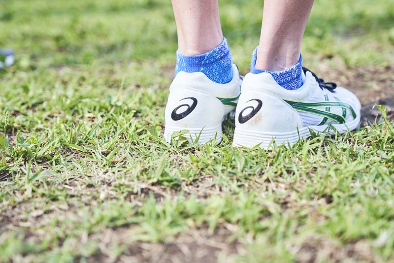 芝生に立つ藤本珠輝の足元