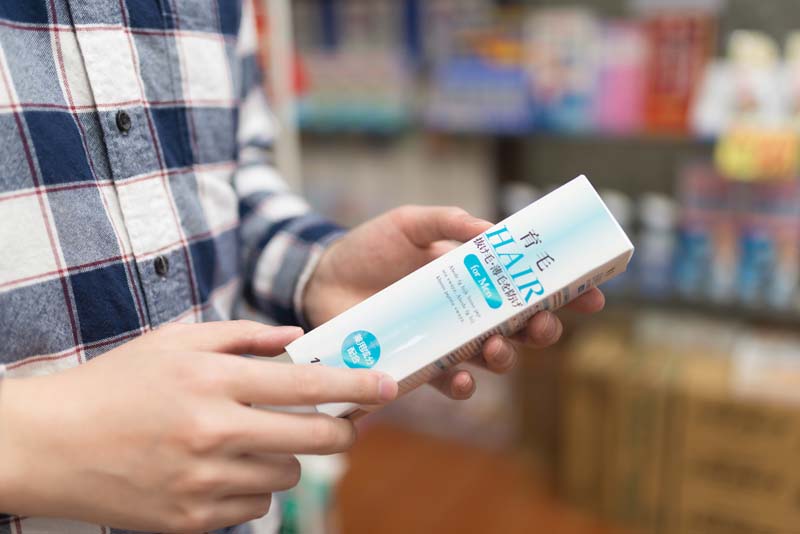 育毛剤を手に取る男性の手元を写した写真