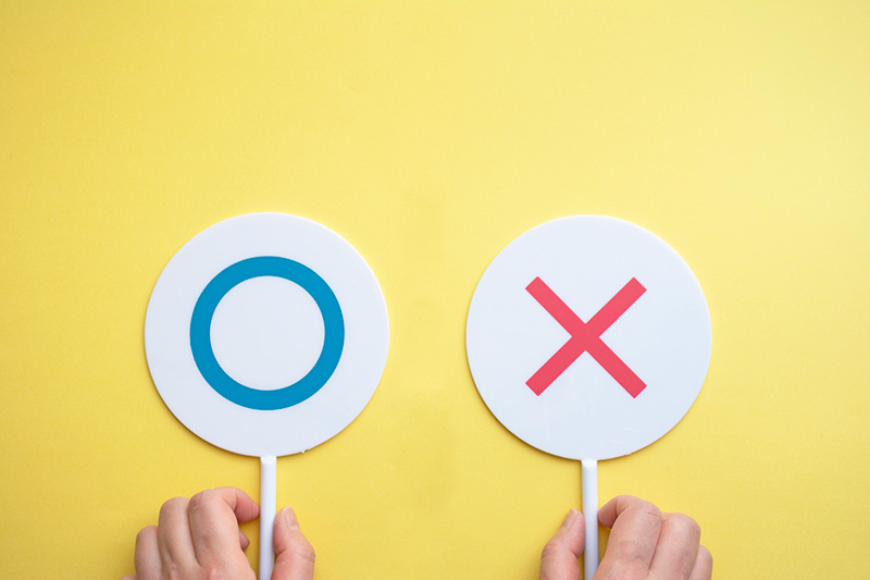 〇と✕のプラカードを持つ人