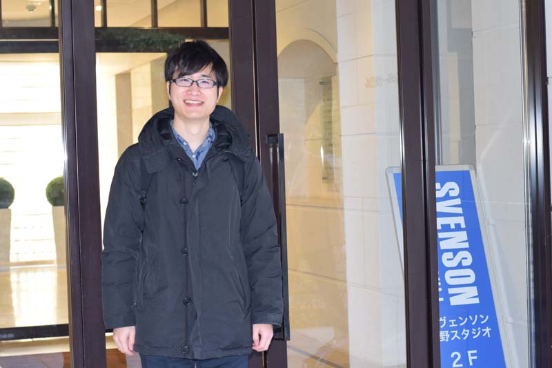 スヴェンソン 上野スタジオの入り口前に立つコクブさん(笑顔)