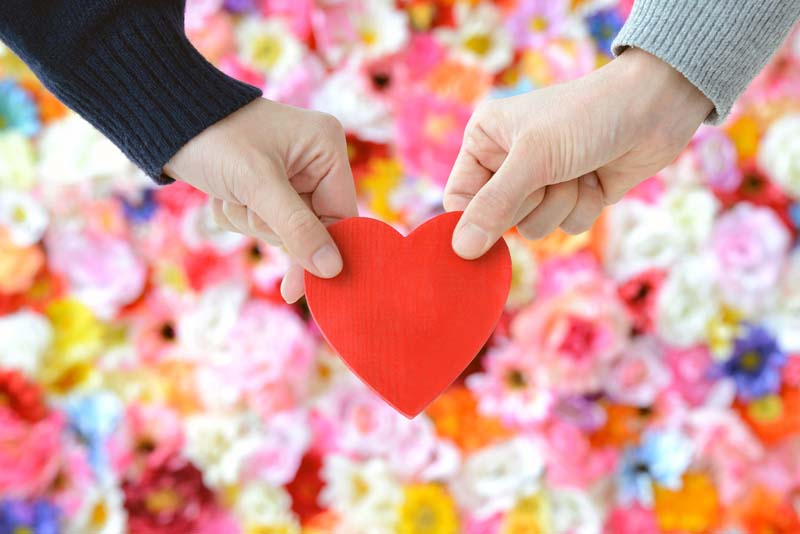 一緒にハートの積み木を持つ男女の手
