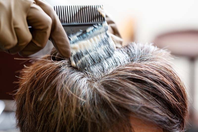 髪の根元に白髪染めをつけている様子