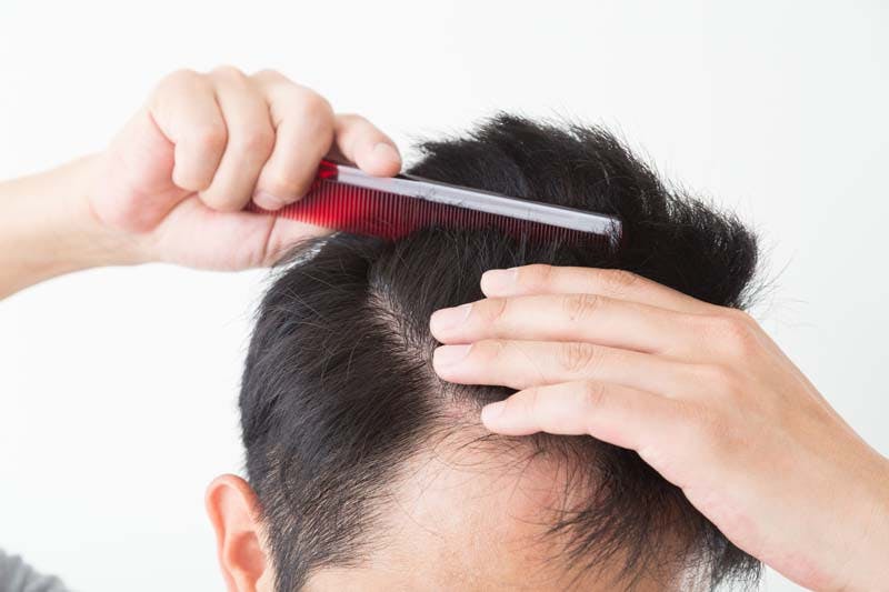 短髪の男性がヘアスタイリングをする様子