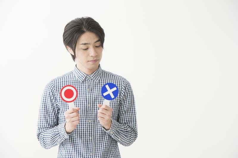 男性がメリットデメリットを比較して悩むイメージ画像