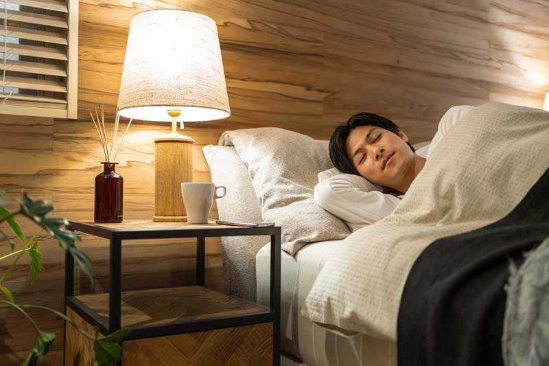 寝室でぐっすり眠る男性のイメージ画像