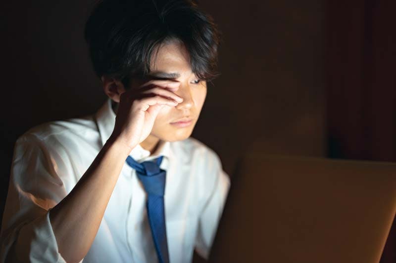 夜遅くまで仕事をする男性のイメージ画像