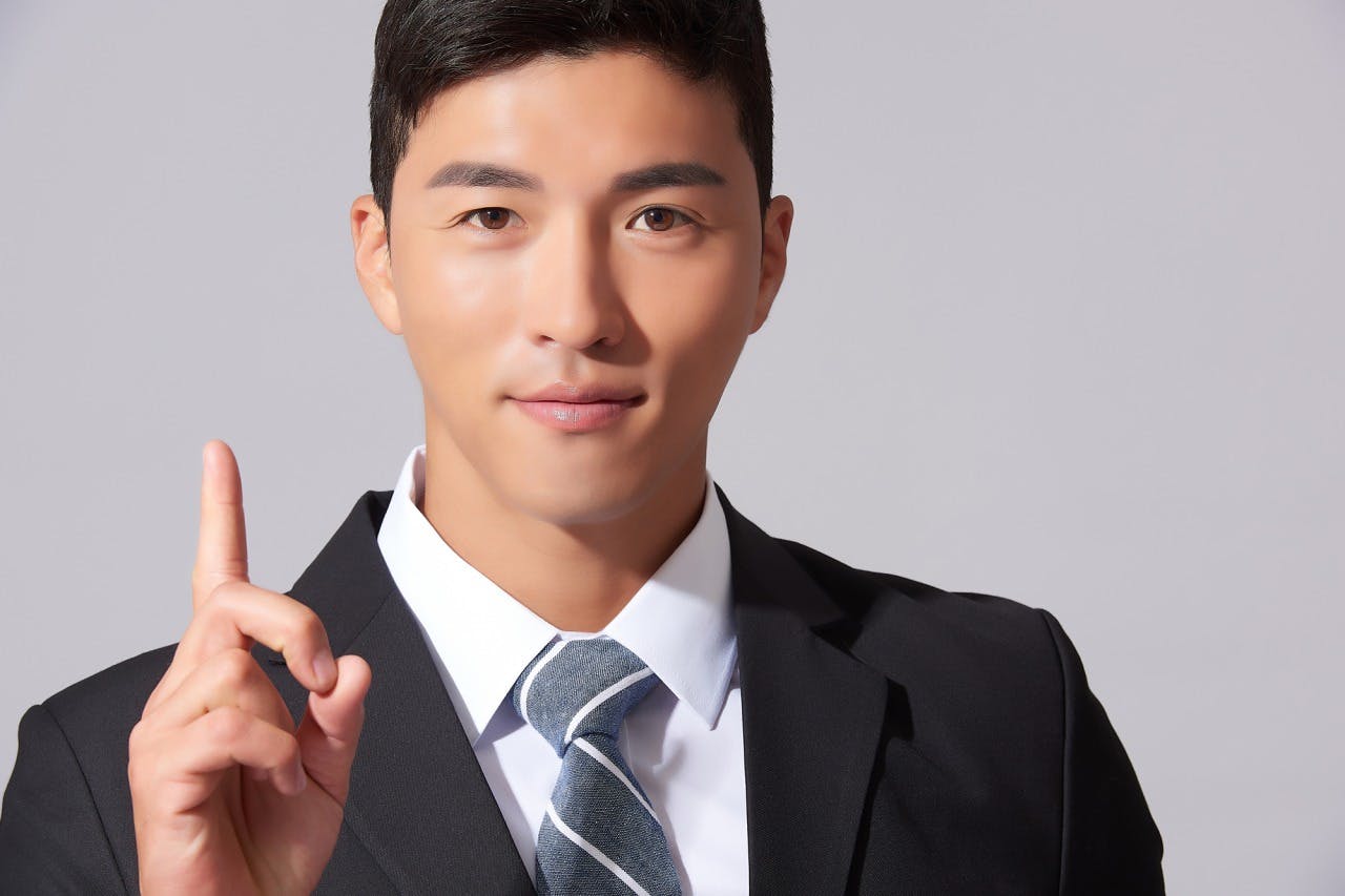にこやかに人差し指を立てる男性