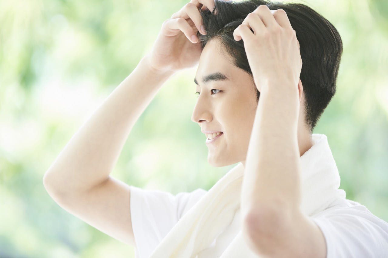 髪の毛をいじる男性の横顔