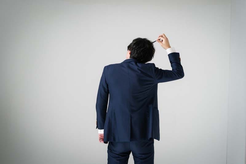 髪の毛が気になって触る男性のイメージ画像