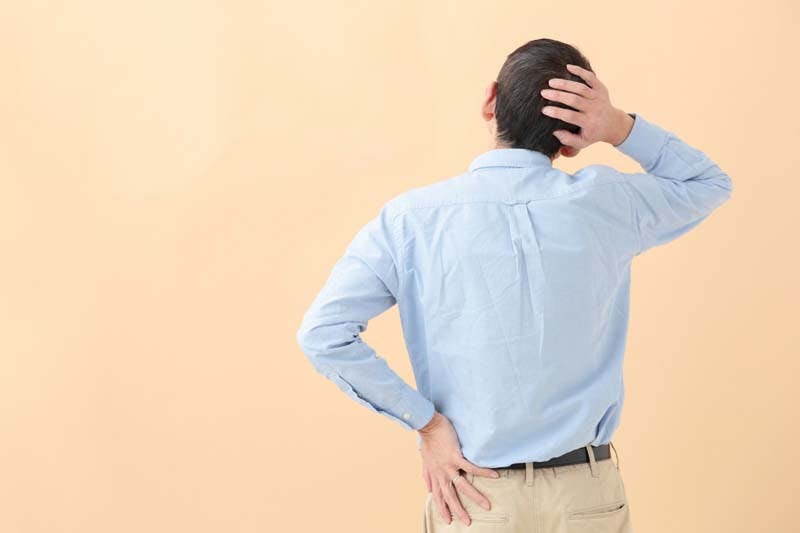 後頭部の髪の毛を気にして触っている男性のイメージ画像