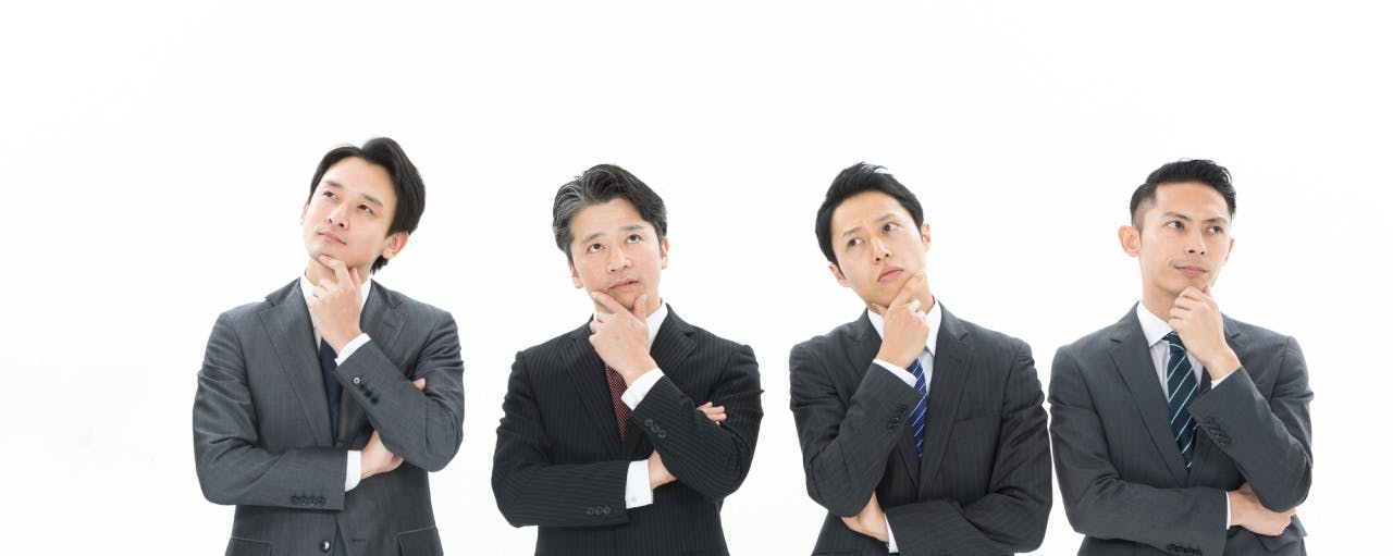 首をかしげる4人の男性の写真
