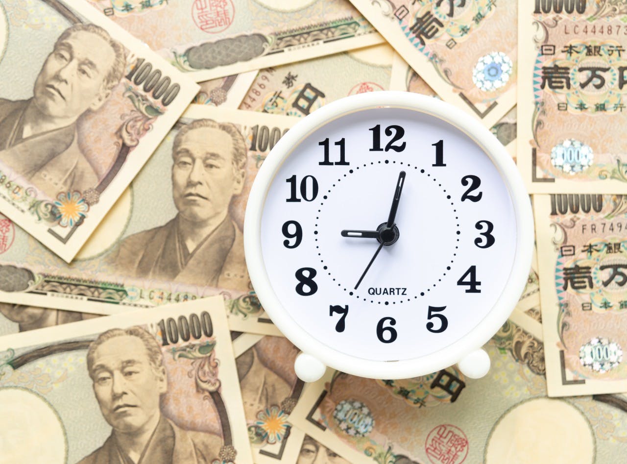 時計と散らばる1万円札の写真