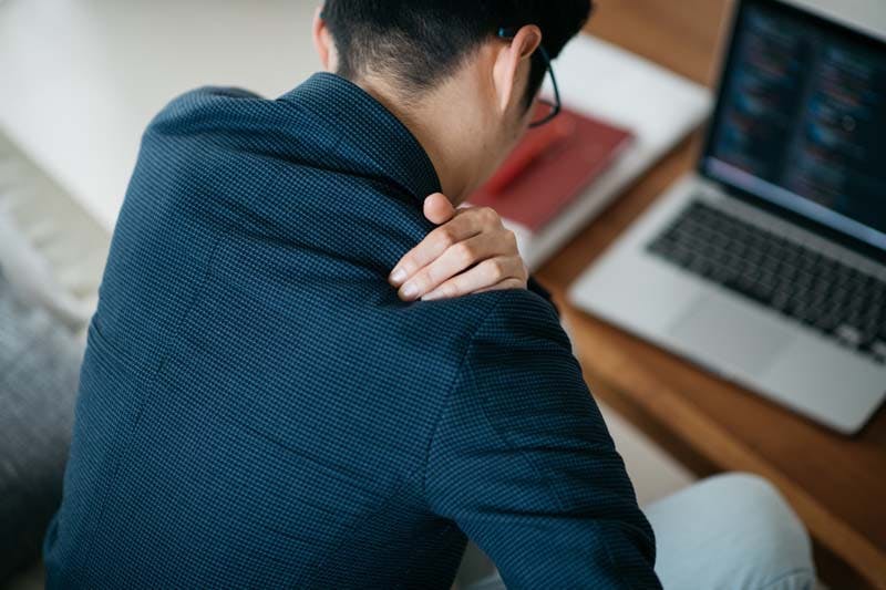 肩こり・疲れを感じる男性のイメージ画像