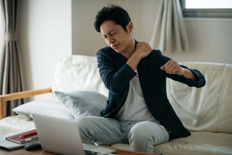 運動不足で肩が凝っている男性のイメージ画像