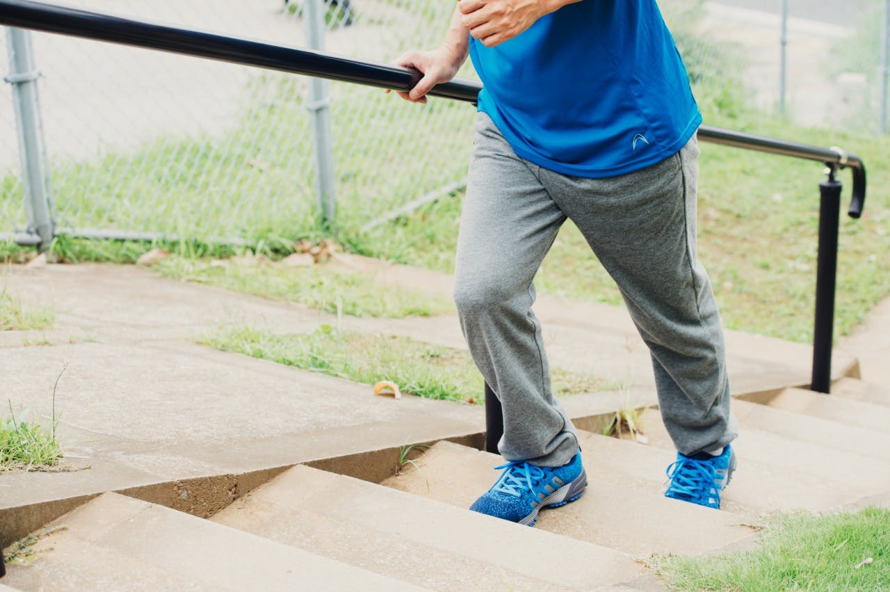 階段を登ってウォーキングしている男性のイメージ画像