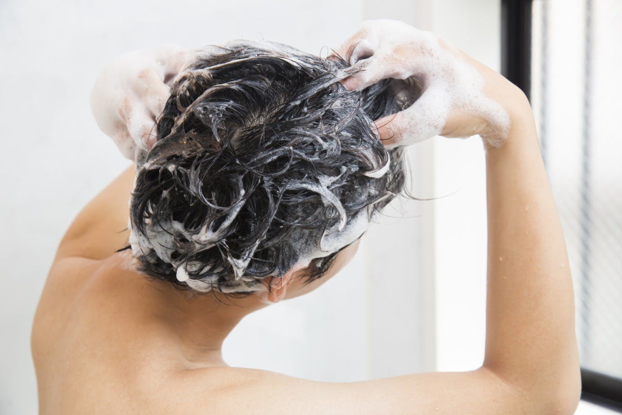 正しいシャンプー方法で洗髪する男性