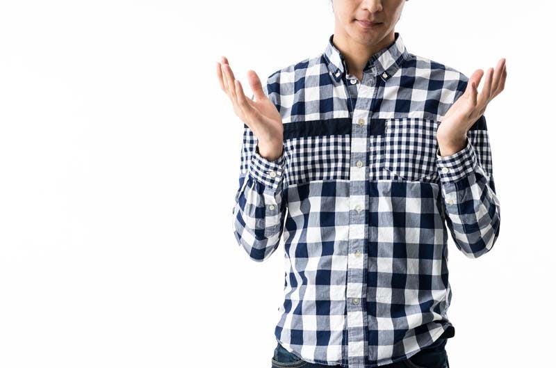 諦めのポーズをとる男性のイメージ画像