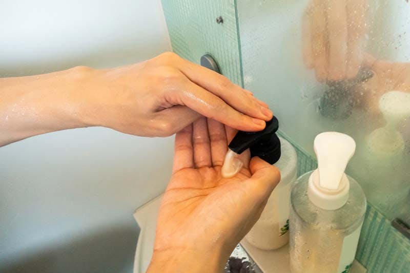 シャンプーを手に取る様子のイメージ画像