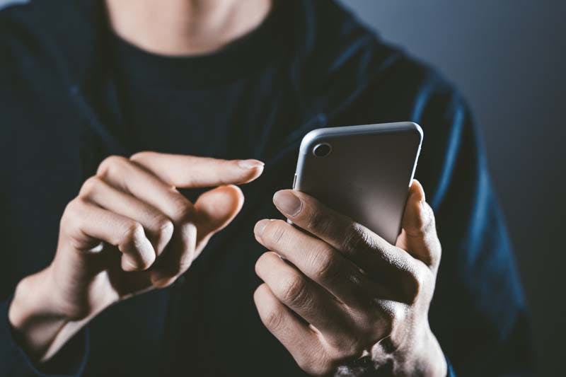 スマホの画面を操作する男性のイメージ画像