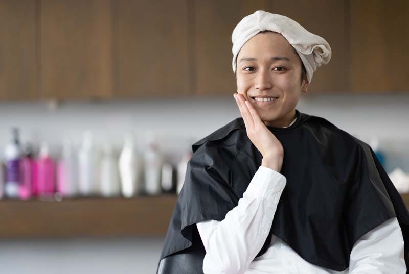 美容室で笑顔で施術を受ける男性の画像